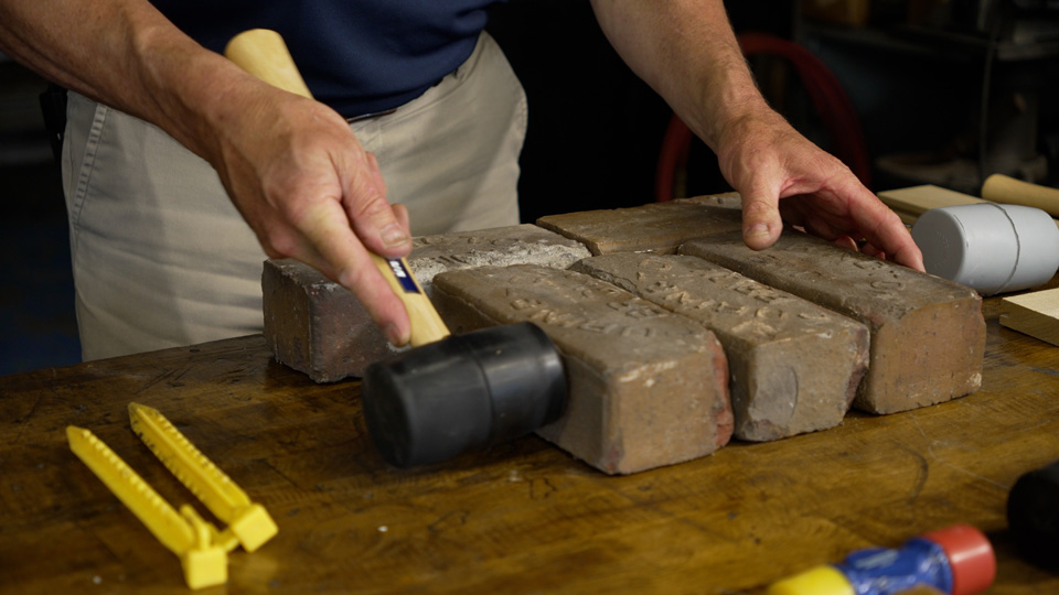 tapping pavers into place with the solid rubber mallet
